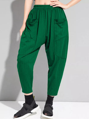 Dark green plus size harem pants with pockets and a ribbed texture.