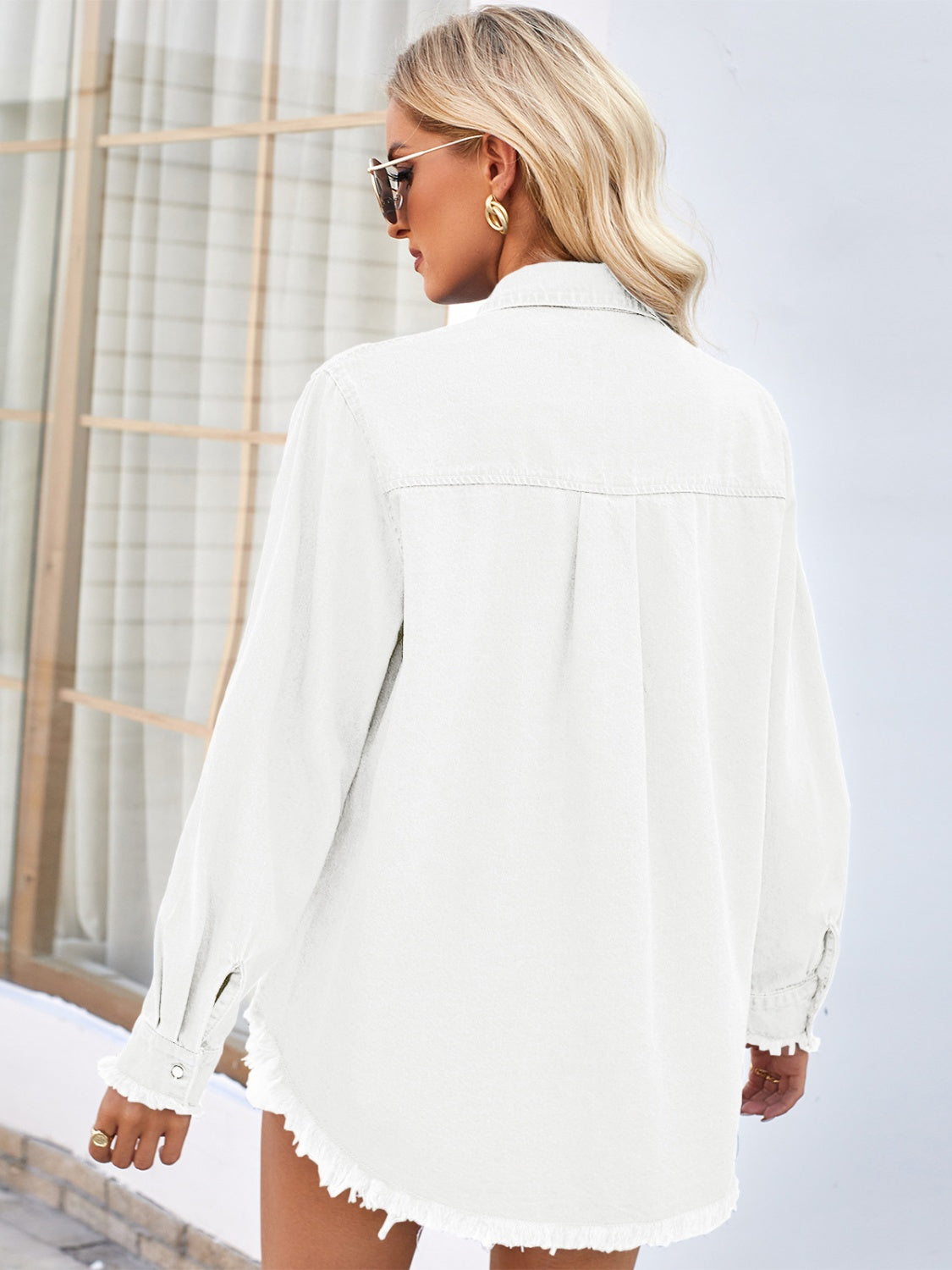 White denim shirt with frayed hem and cuffs, long sleeves, button front, and back yoke detail.