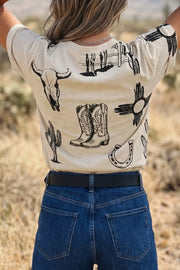 Cream crew neck t-shirt with western graphic print including cowboy boots, bull skull, cactus, and horseshoe.