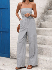 Strapless wide leg romper in navy and white stripes, cotton blend, with a cinched waist and pockets.