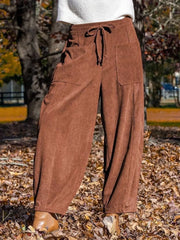 Brown corduroy wide-leg pants with drawstring waist and pockets.