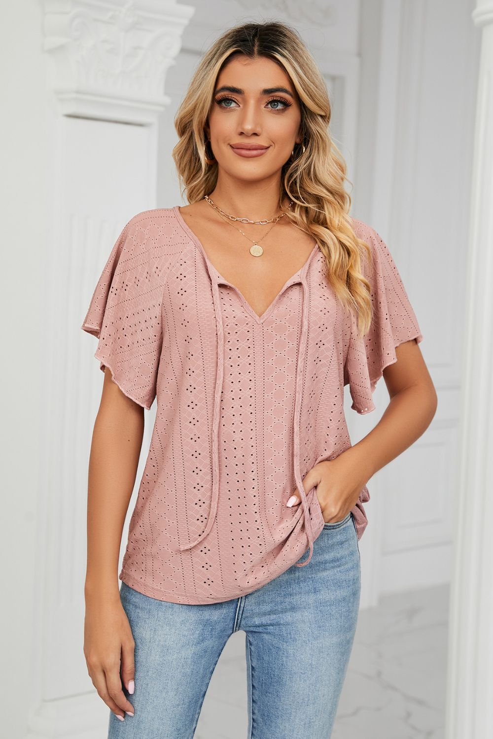 Pink eyelet tie-neck blouse with flutter sleeves and V-neck