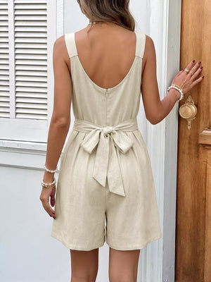 Beige linen blend romper with bowknot belt and pleated shorts.