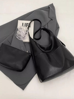 Luxurious black hobo shoulder bag with adjustable strap and matching pouch.