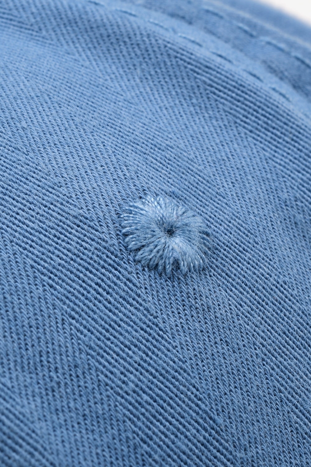 Cobalt blue denim baseball cap with raw edge detail and embroidered eyelet.