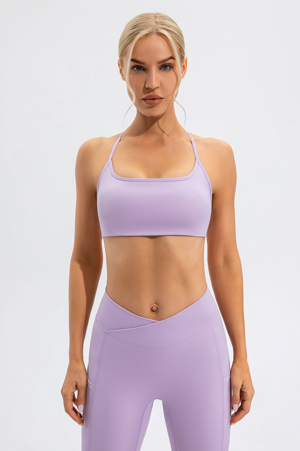 Lilac sports bra with crisscross back straps and matching high-waisted leggings.