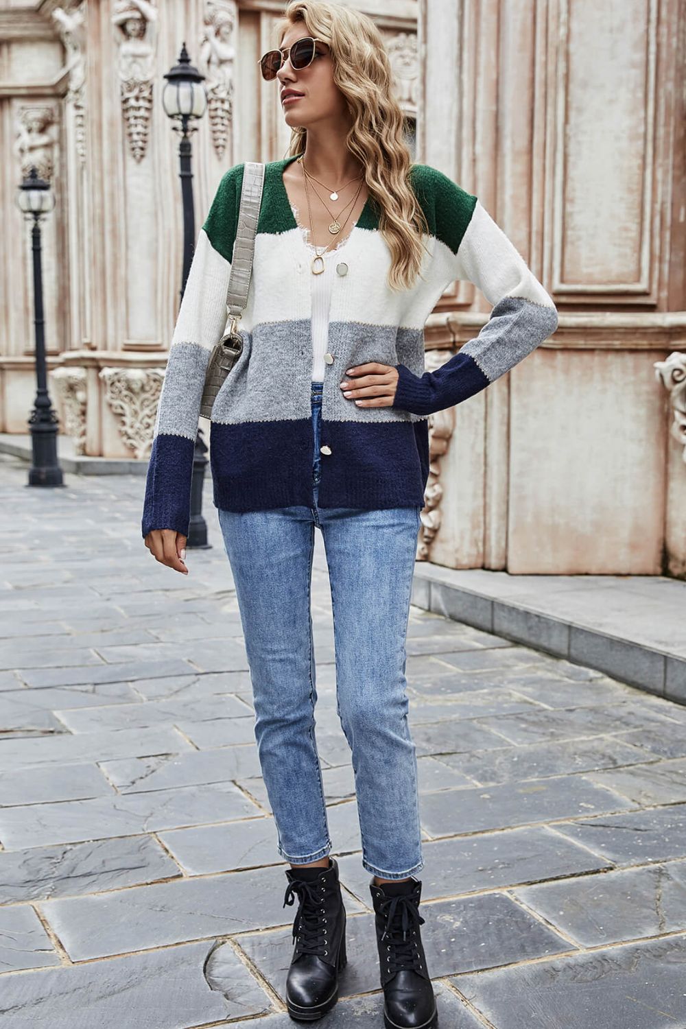 Colorblock acrylic cardigan with metallic trim in green, white, grey, and navy blue.