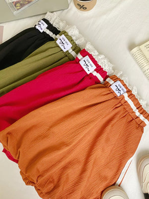 Lace-trimmed gathered waist mini skirts in red, army green, orange, and black with textured fabric.