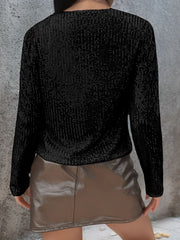 Black sequin bolero jacket with long sleeves and a textured finish.