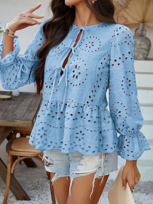 Light blue eyelet embroidered peplum tie blouse with bell sleeves and ruffled cuffs.