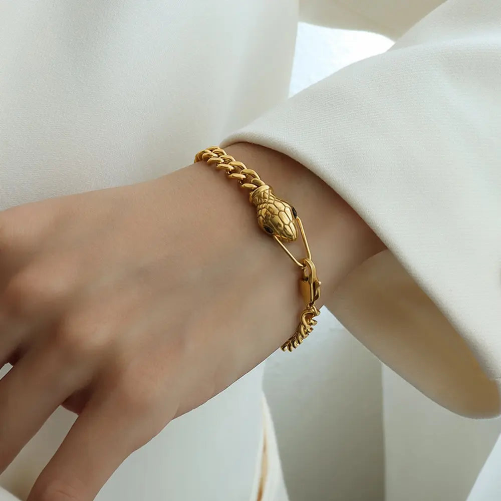 Gold serpentine chain bracelet with snake head detail and clasp.