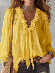 Yellow frilled tie-front shirt with ruffled neckline and long sleeves.