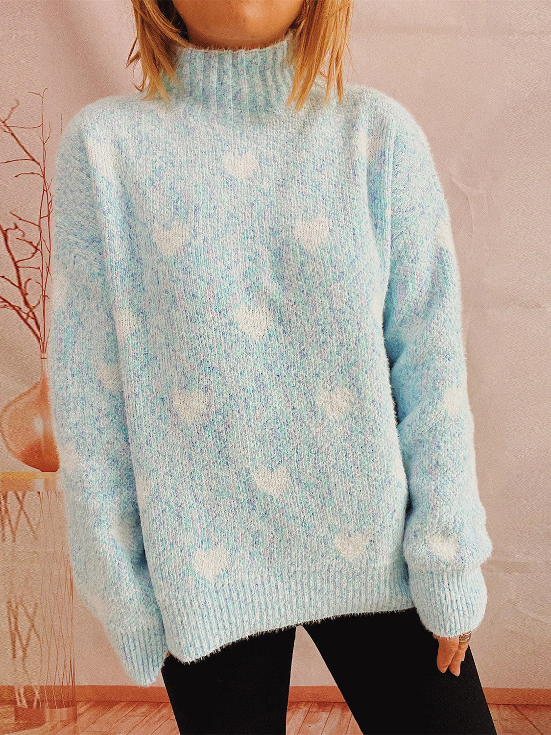 Mint blue acrylic turtleneck sweater with white heart pattern and textured knit.
