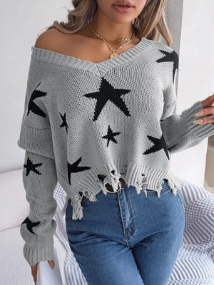 Gray distressed V-neck knit sweater with black stars and frayed hem.