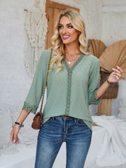 Sage green eyelet blouse with V-neck and lace trim details.