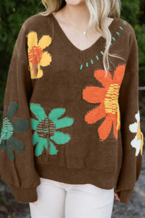 Brown V-neck knit sweater with colorful embroidered floral appliques and stitching details.