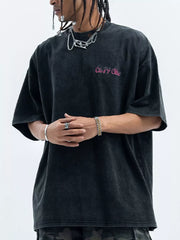 Men's black washed cotton t-shirt with pink graphic logo and crew neck.