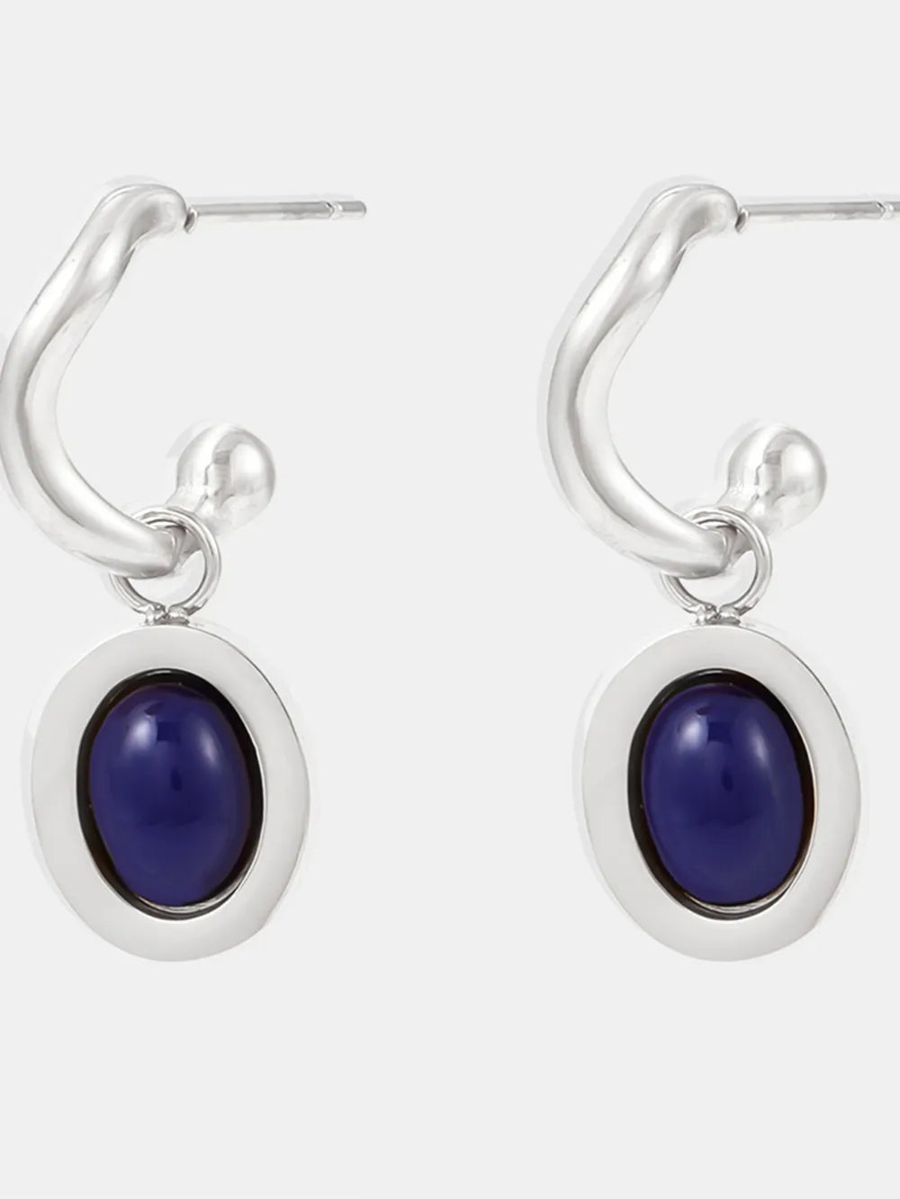Sculptural hoop earrings with oval blue stone inlays and silver hardware.