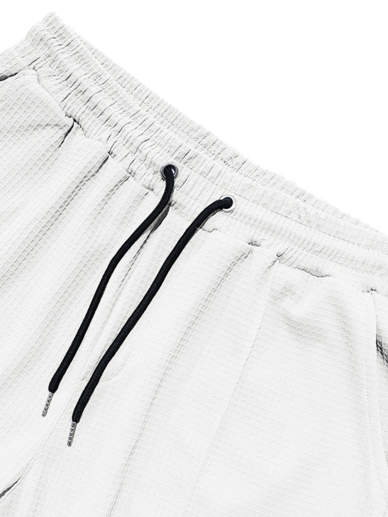 White textured drawstring sweatpants with black drawstrings and metal tips.