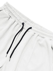 White textured drawstring sweatpants with black drawstrings and metal tips.