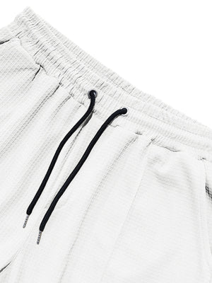 White textured drawstring sweatpants with black drawstrings and metal tips.