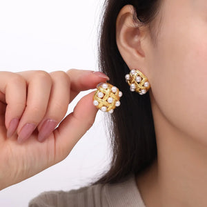 Gold woven pearl grid earrings with a textured finish.