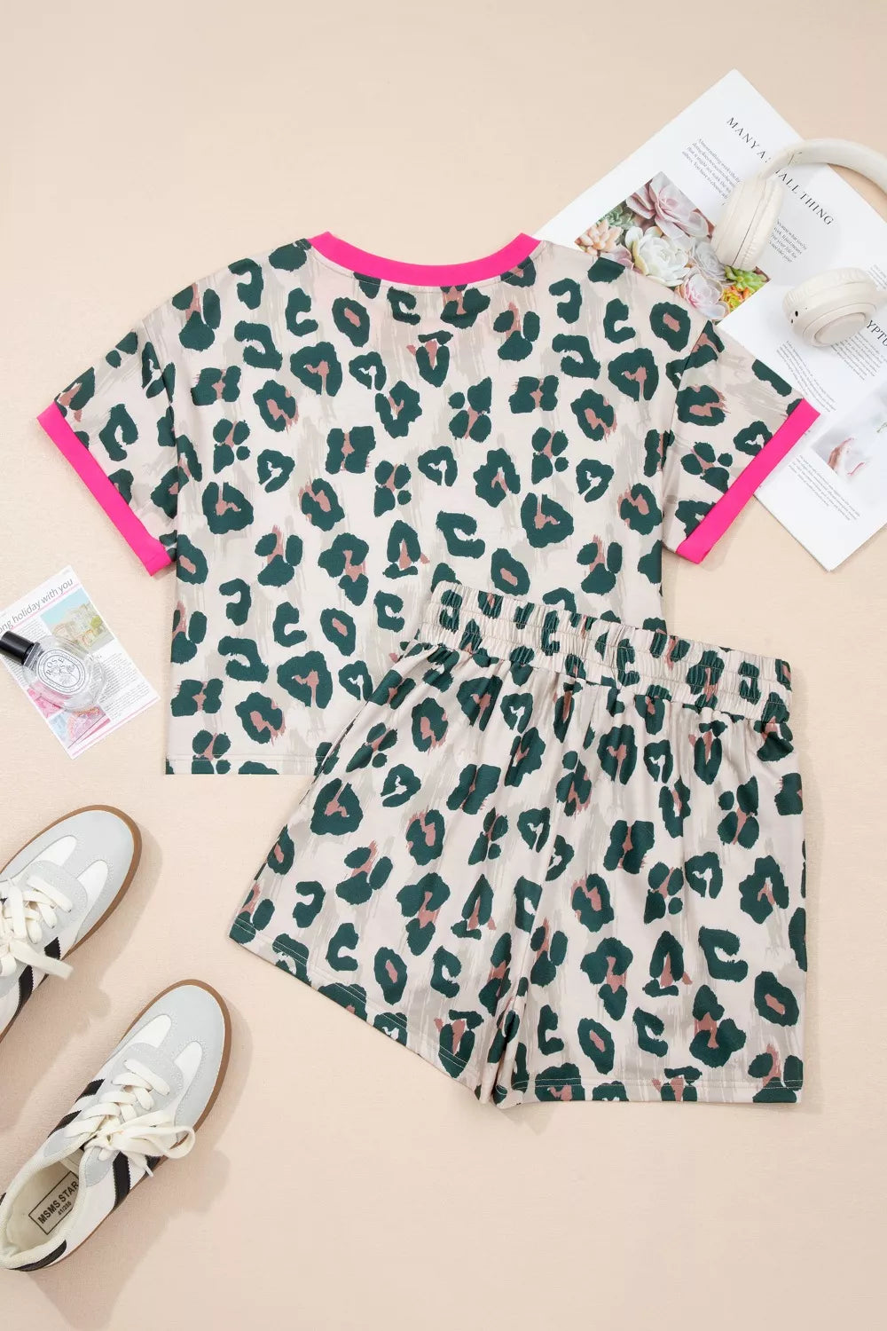 Leopard print pajama set with pink trim, featuring a short sleeve top and elastic waist shorts.