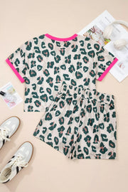 Leopard print pajama set with pink trim, featuring a short sleeve top and elastic waist shorts.