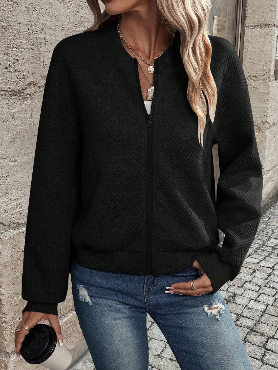 Black geometric quilted bomber jacket with zip front and crew neck.