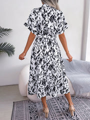 Dalmatian print midi shirt dress in white with black spots, short sleeves, and tie waist.