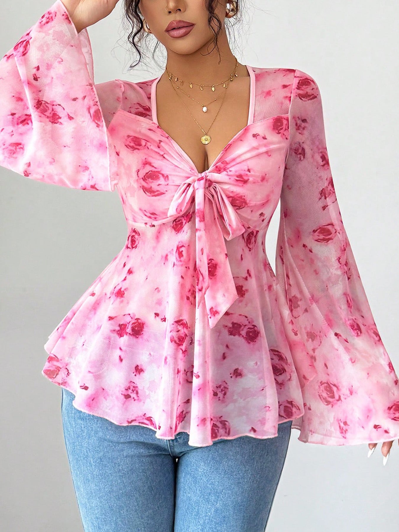 Pink floral chiffon blouse with tie-front and bell sleeves.