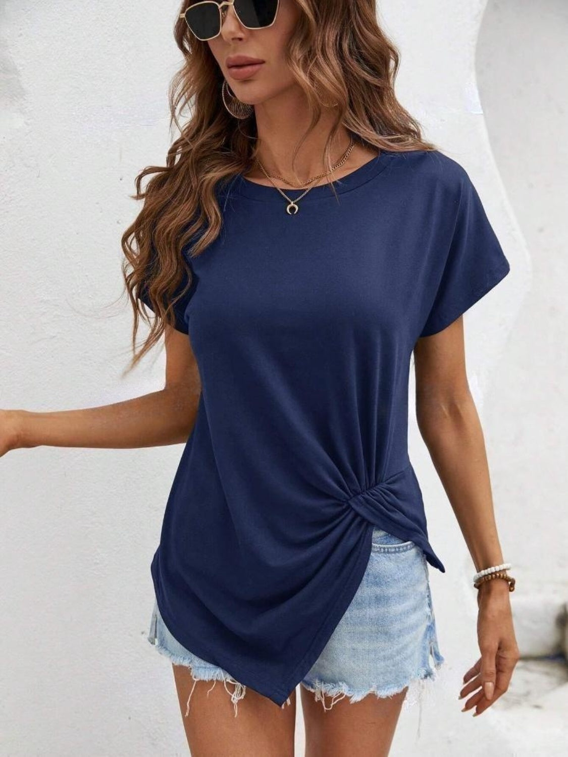 Dark blue t-shirt with short sleeves and a draped knot front detail.