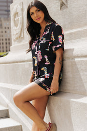 Black silk pajama set with colorful boot print and pink trim.