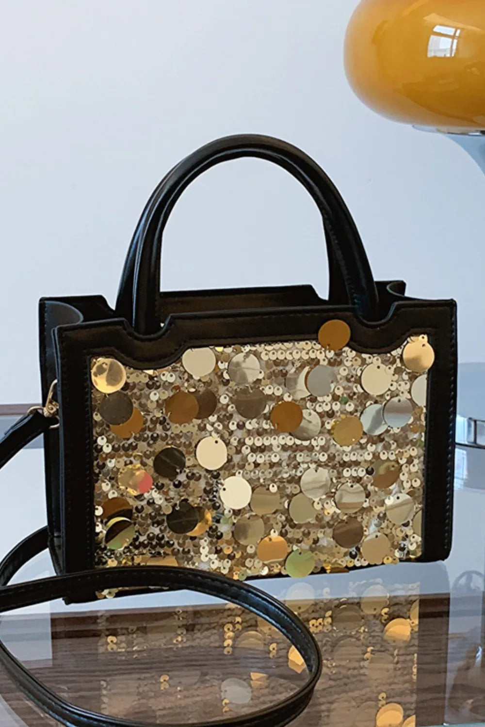 Black structured mini bag with gold sequin embellishments and top handles