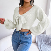 White ribbed knit crop top with V-neck and bow detail, long sleeves