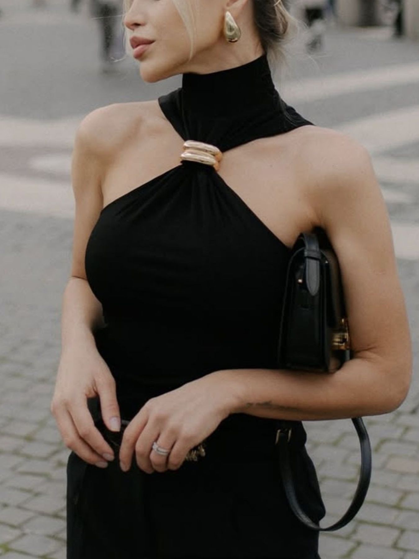 Black asymmetrical halter neck tank top with gold ring detail.