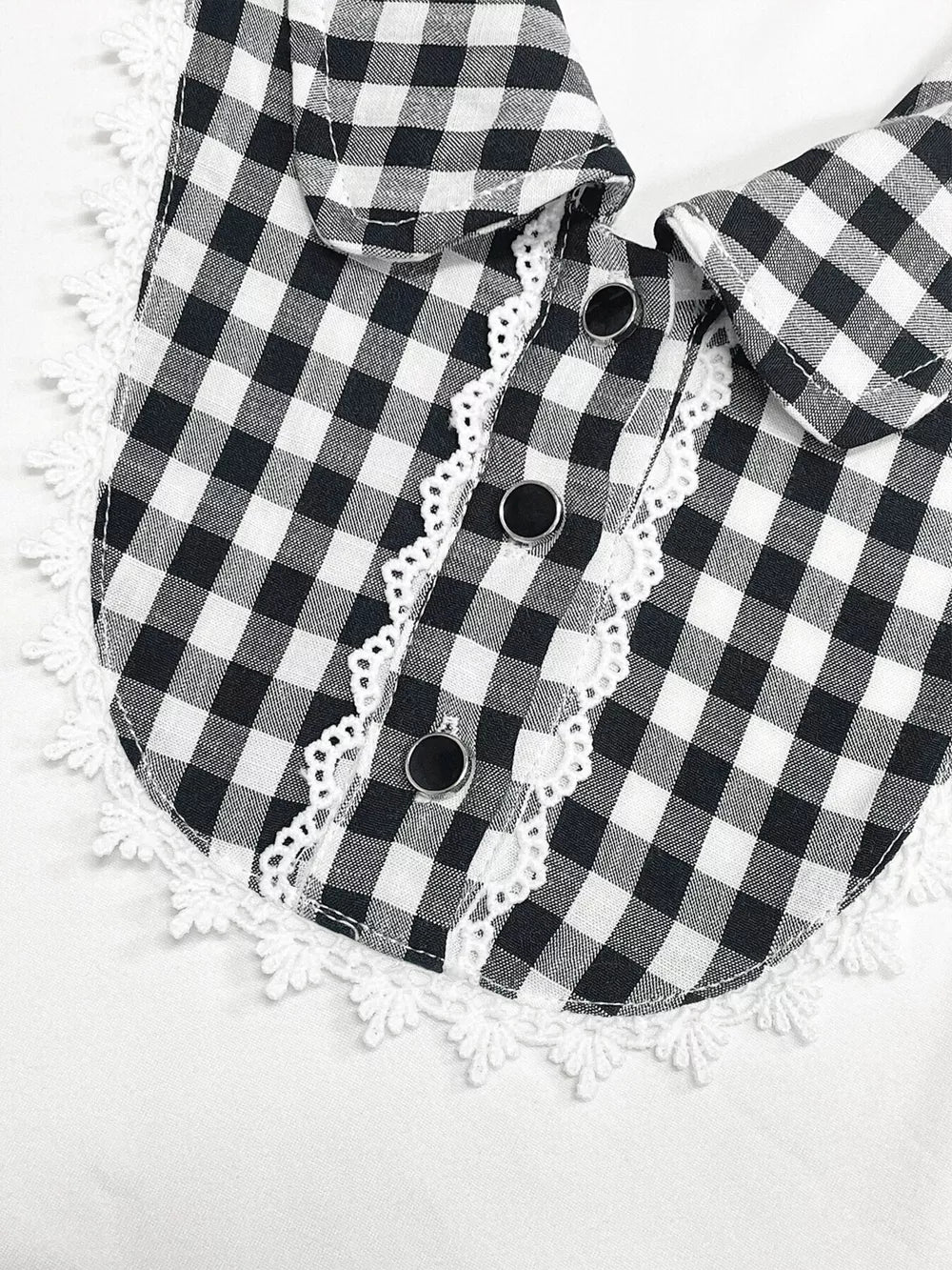 Black and white gingham maternity shirt with lace trim collar and decorative buttons.