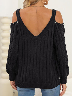 Black cable knit sweater with cold shoulder detail and pearl buttons, V-neck.