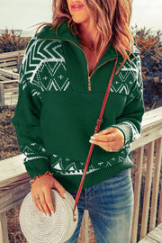 Dark green knit pullover with white geometric pattern and zip neck.