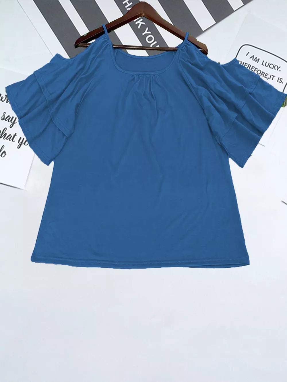 Blue t-shirt with gathered neckline and ruffled cold shoulder sleeves.