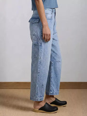 Light wash denim maternity jeans with wide legs and utility pockets.