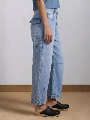 Light wash denim maternity jeans with wide legs and utility pockets.