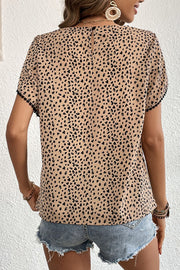Leopard print blouse with pom-trim sleeves and a keyhole back detail.