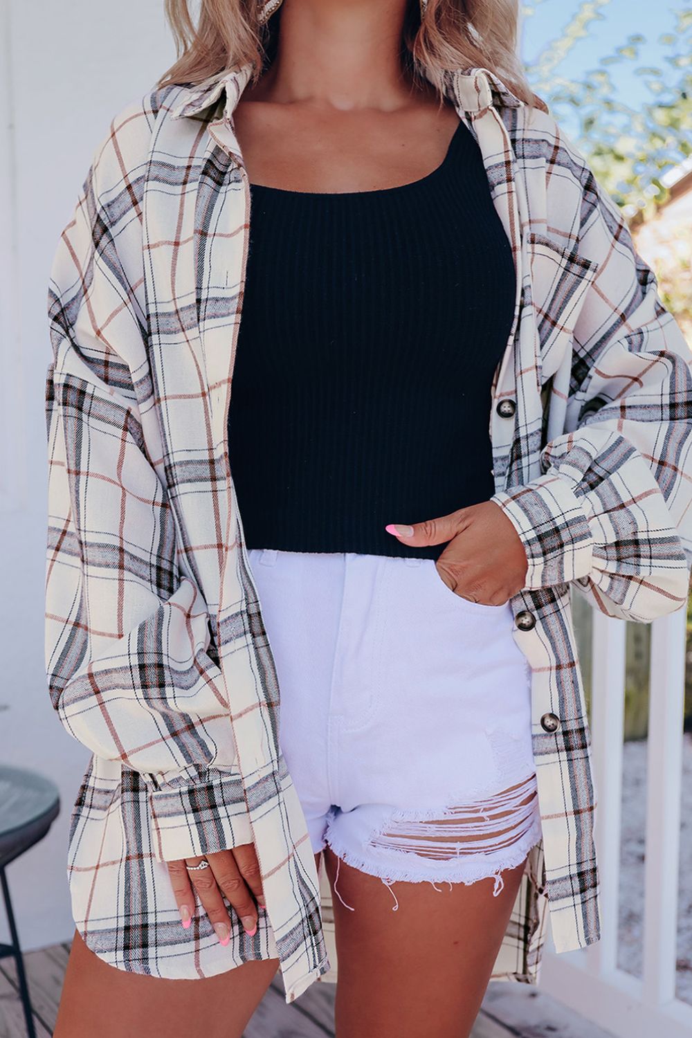 Oversized white plaid shacket with button front and cuffs, worn open over a black tank top.