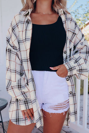Oversized white plaid shacket with button front and cuffs, worn open over a black tank top.
