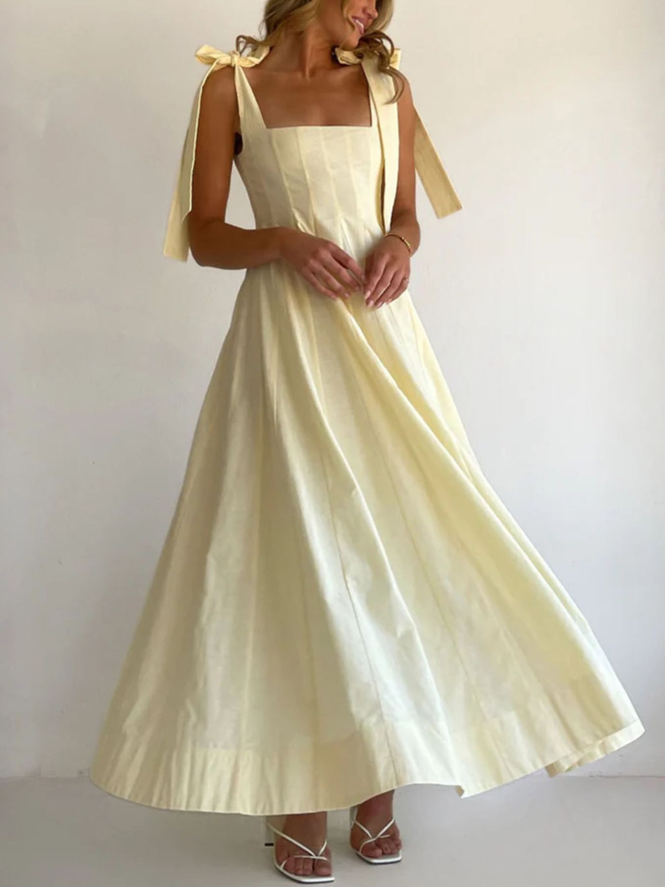 Yellow maxi dress with square neckline and bow-tie shoulder straps.