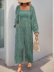 Turquoise floral jumpsuit with square neck, smocked waist, long sleeves, and wide legs.