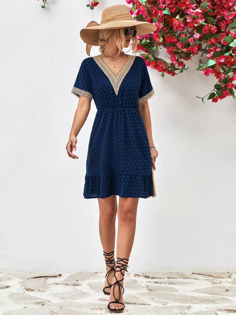 Navy Swiss dot mini dress with V-neck and lace trim details.