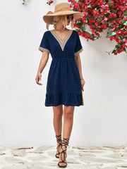 Navy Swiss dot mini dress with V-neck and lace trim details.