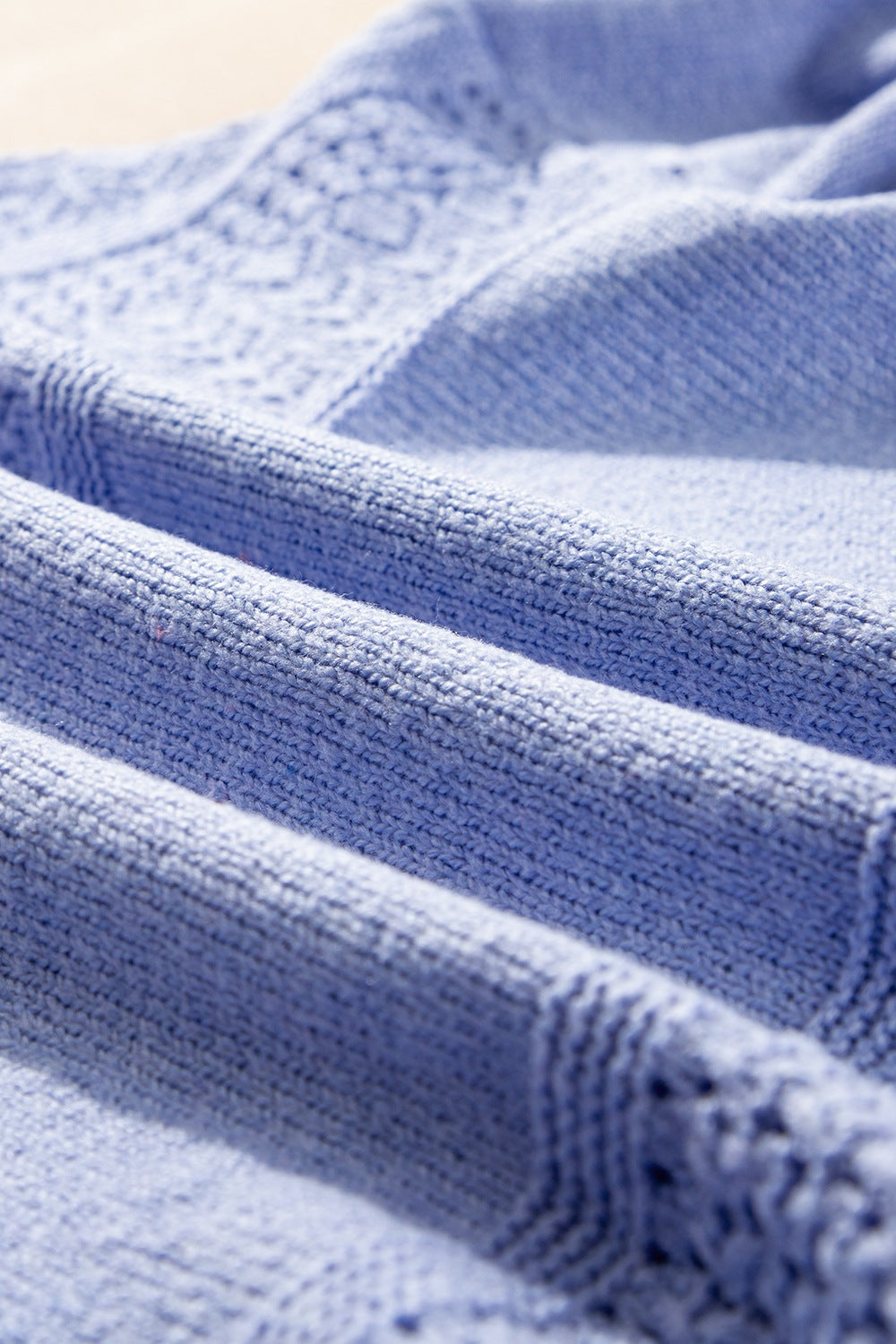 Light blue perforated knit V-neck pullover sweater with textured detail.